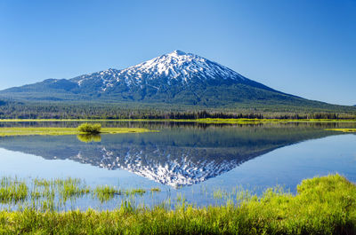 Mt bachelor by lake against clear sky