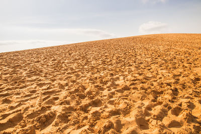 Sand dunes in desert against sky