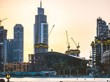 Modern buildings against sky at sunset