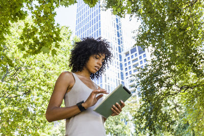 Germany, frankfurt, young woman using tablet in the city