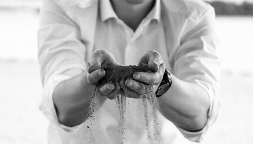 Midsection of man holding sand 