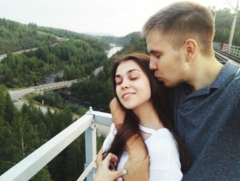 Young couple looking at lake against mountain