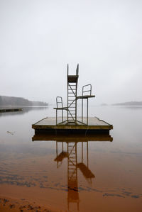 Lifeguard hut in lake against sky