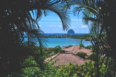 Scenic view of village next to sea against cloudy sky