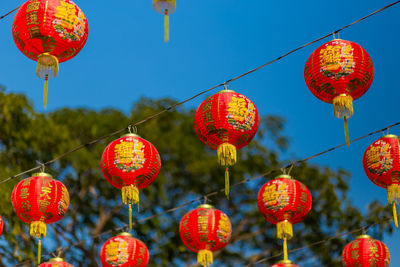 Low angle view of lanterns hanging against sky