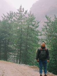 Man standing against trees in forest