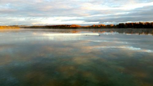 Scenic view of lake against cloudy sky