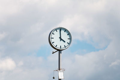 Low angle view of clock against sky