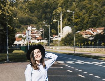 Smiling woman standing on road in city