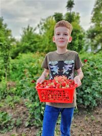 Portrait of boy standing against plants