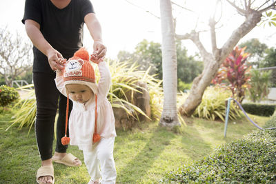 Rear view of mother and daughter standing on plant