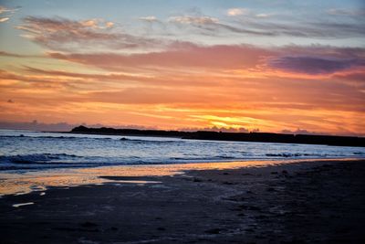 Scenic view of beach against sky during sunset