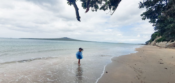 Man standing on beach against sky