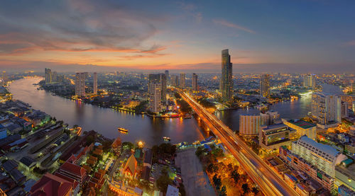 Aerial view of illuminated cityscape during sunset