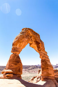 View of natural arch against clear sky during sunny day