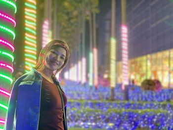 Woman standing in illuminated city at night