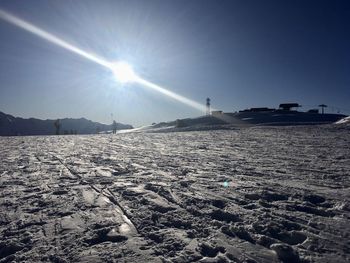 Scenic view of snowcapped landscape against sky on sunny day