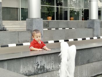 Baby boy looking at fountain outside building