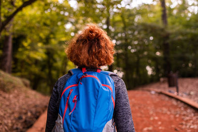 Rear view of woman standing against trees