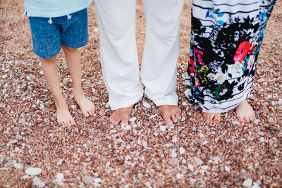 Low section of people standing on pebbles