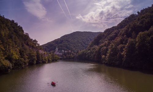 Scenic view of river amidst trees against sky