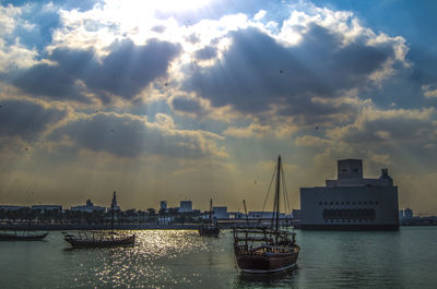 Sailboats moored in sea against sky