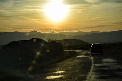 Car on road against sky during sunset