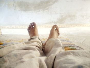 Low section of man lying on bed