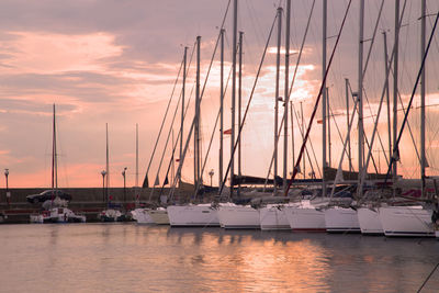 Boats in harbor at sunset