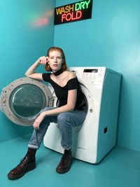 Portrait of a woman sitting in a washing machine 