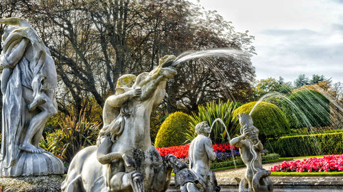 Statue in park against sky