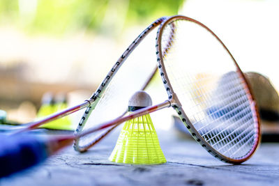 Close-up of badminton racket with shuttlecock on floor