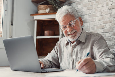 Senior man using laptop at office