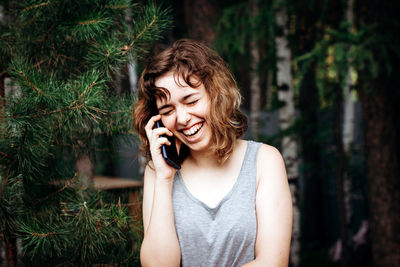 Young woman looking away while standing outdoors