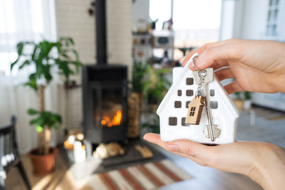 Cropped hand of woman holding model house