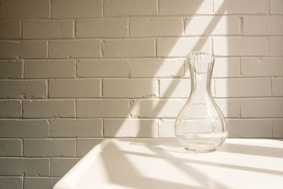 Close-up of glass on table against wall