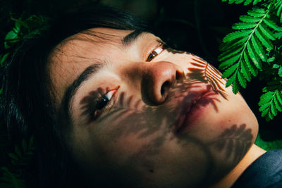 Close-up portrait of young woman in grass