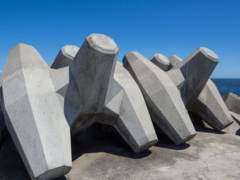 View of concrete and sea against blue sky