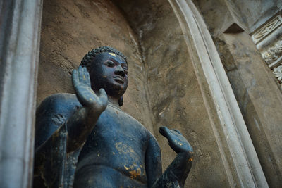 Low angle view of statue against old building