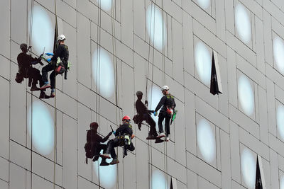 Low angle view of people working on building