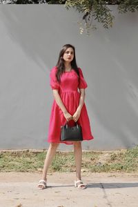 Portrait of young woman standing on field