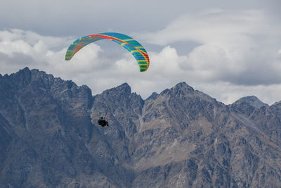 Person paragliding against mountain