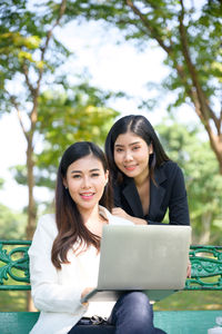 Portrait of a smiling young woman using phone