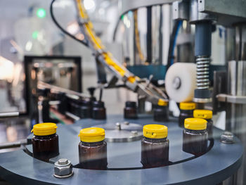 Plastic bottles with medicine on conveyor of capping machine in pharmaceutical manufacturing laboratory