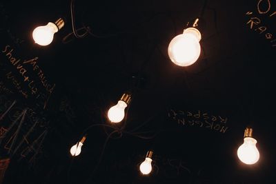 Low angle view of illuminated lights against sky at night