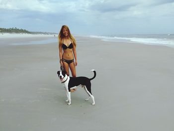 Smiling woman with dog at beach