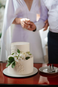 Newlyweds hold hands and cut the cake