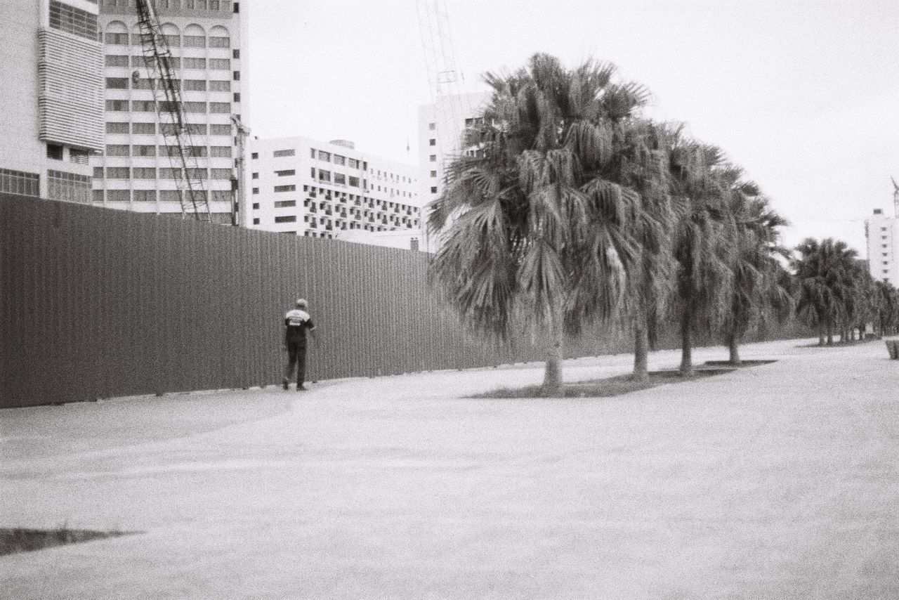 PEOPLE WALKING ON STREET AMIDST BUILDINGS