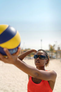 Woman with afro hair playing beach volleyball