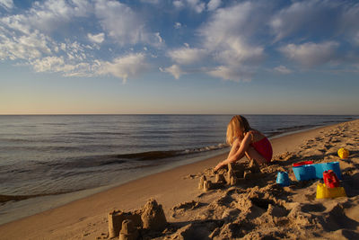 Rear view of people sitting on beach